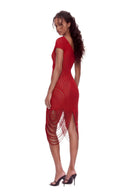 Angled back view of the red asymmetric draped sheer midi dress, showing the garment silhouette and back detailing.