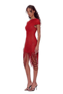 Opposite front angle view of the red asymmetric draped sheer midi dress, showing an asymmetric neckline, curved sheer stripes and long looped fringe.