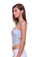 Aveline 3D hand-painted floral tie-back crop top in Pastel Blue, side view showing the gathered bust, side cutout and pointed hem