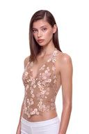 Florielle floral halter top in Warm Nude, three-quarter front view showing raised hand-painted flowers, hand-beaded centers and the shaped hem.