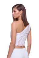 Rear three-quarter view of the Nerina white crop top showing the asymmetric neckline and draped back