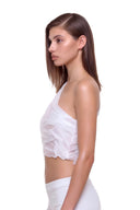 Side view of the Nerina white one-shoulder crop top with sheer panels and a cropped hem
