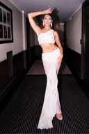 Nerina white one-shoulder crop top and sheer draped skirt set styled with heels, indoor view
