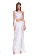 Nerina white one-shoulder skirt set in a walking pose, showing the long sheer skirt and front draping