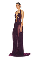 Front three-quarter view of the modena purple Venus wet look gown, showing a chain neckline, bodice cutouts and a long draped skirt.