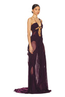 Opposite front three-quarter view of the modena purple Venus wet look gown, showing a chain neckline, bodice cutouts and a long draped skirt.